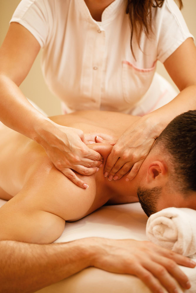 unrecognizable-therapist-massaging-man-s-shoulders-during-spa-treatment